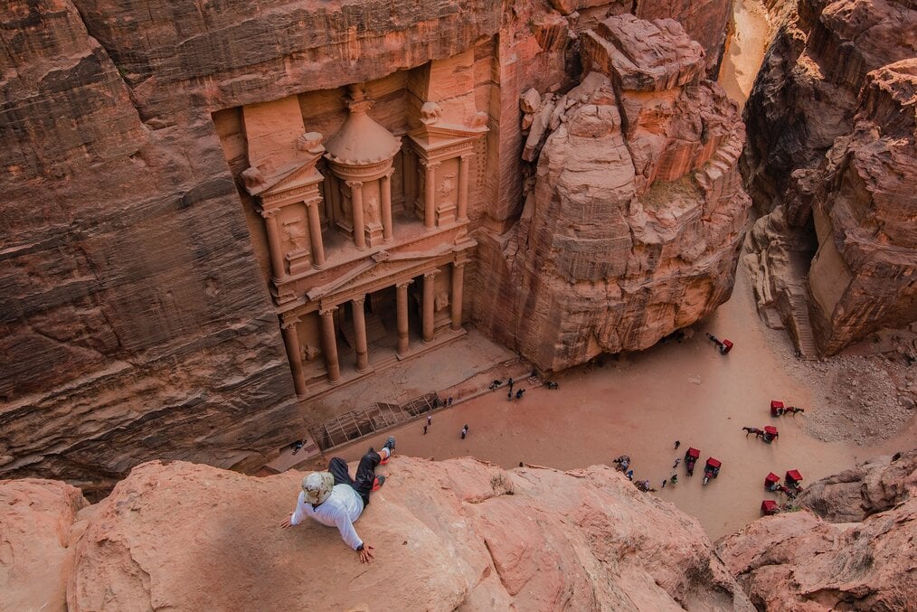 Photo by Ahmad Qaisieh on Unsplash A man sitting on a cliff in Petra, Jordan.
