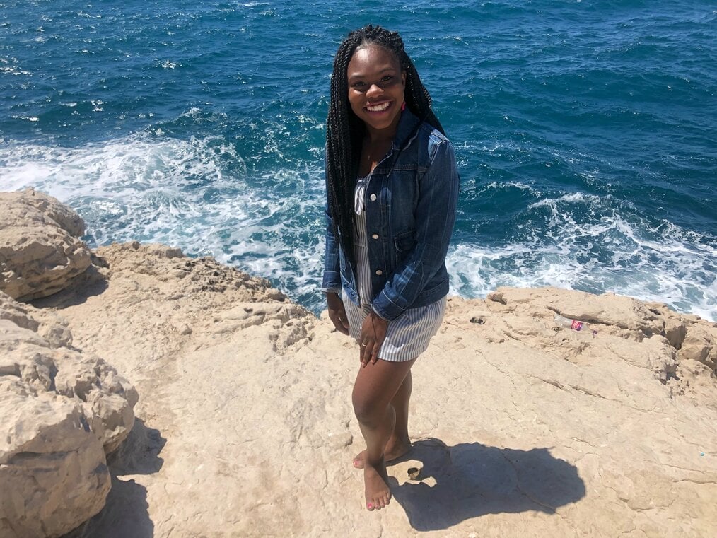 CEA Study Abroad in Aix-en-Provence, France by Rohanna F. A woman poses smiling in front of an ocean.